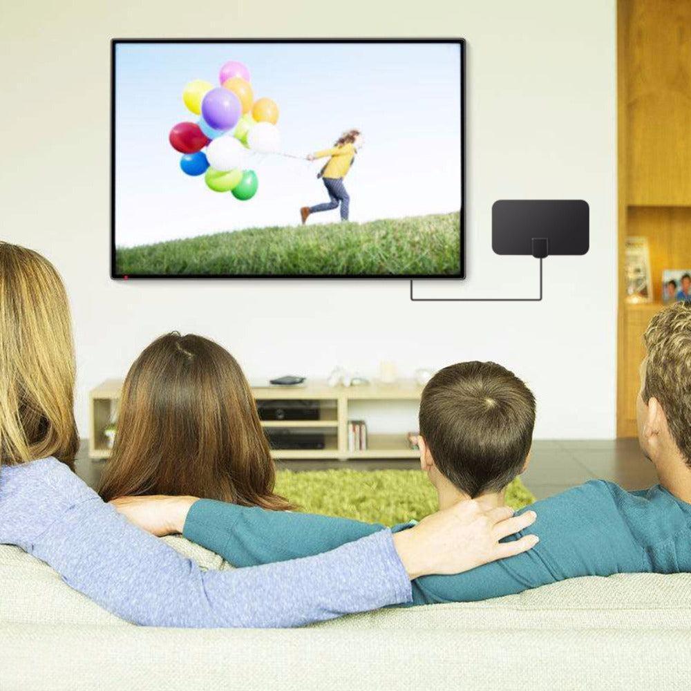 Antena planar ao lado de televisão em sala com pessoas no sofá.