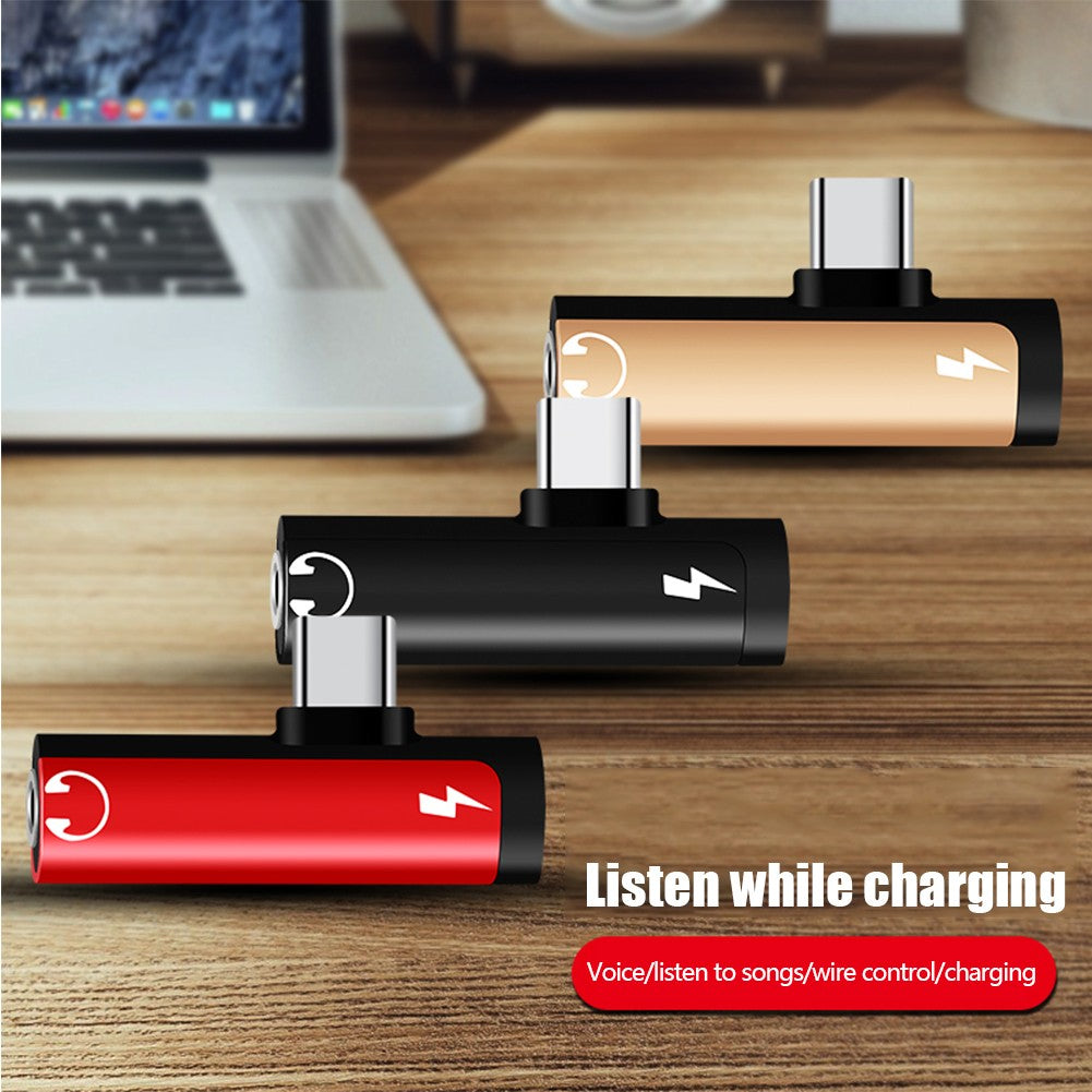 Adaptadores USB-C compactos dourado, preto e vermelho em composição sobre mesa.